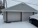Attached two car garage with white doors and red trim during winter at 504 E Walnut St, Summitville, IN 46070