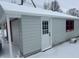 Side view of the garage with red trim and a white door, covered in snow at 504 E Walnut St, Summitville, IN 46070