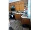 Standard kitchen with older cabinets, gray floors, black appliances, and steel sink at 504 E Walnut St, Summitville, IN 46070
