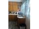Standard kitchen with older cabinets, gray floors, and a stainless steel sink at 504 E Walnut St, Summitville, IN 46070