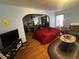 View of living room and arched doorway to dining room, with hardwood floors and area rug at 504 E Walnut St, Summitville, IN 46070