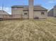 Exterior view of home's backyard showcasing a wooden deck, siding, and partially snow covered lawn at 6462 Zionsville Rd, Indianapolis, IN 46268