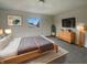 A cozy bedroom featuring neutral walls, a queen bed, and a natural wood dresser at 6462 Zionsville Rd, Indianapolis, IN 46268