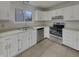 Updated kitchen featuring sleek stainless steel appliances, white cabinets, and modern fixtures at 6462 Zionsville Rd, Indianapolis, IN 46268