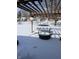 Snowy backyard featuring a patio and a basketball hoop at 720 Mount Rainier Dr, Indianapolis, IN 46217