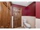 Bathroom featuring toilet, tiled walls, and wooden door at 7705 N State Road 42, Stilesville, IN 46180