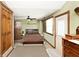 This carpeted bedroom has a ceiling fan, natural lighting, and a door to the exterior at 7705 N State Road 42, Stilesville, IN 46180