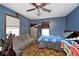 Bedroom features hardwood floors, natural light, and blue walls at 7705 N State Road 42, Stilesville, IN 46180