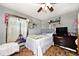Cozy bedroom featuring a ceiling fan, shelves, TV, and a comfortable bed with natural light at 7705 N State Road 42, Stilesville, IN 46180