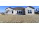 Backyard view of a modern home featuring large windows and a freshly seeded lawn with a concrete patio at 10502 Oak Bend Blvd, Indianapolis, IN 46239