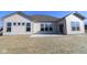 Back of home showing plenty of windows, concrete patio and a large yard at 10502 Oak Bend Blvd, Indianapolis, IN 46239