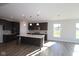 Open-concept kitchen with a large island, dark cabinetry, and pendant lighting, seamlessly flowing into other spaces at 10502 Oak Bend Blvd, Indianapolis, IN 46239