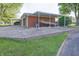 Carport and paved driveway, next to brown siding and manicured landscaping at 1231 S Catherwood Ave, Indianapolis, IN 46203