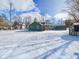 Spacious backyard with snow and showing the home and garage exteriors at 1235 Indiana Ave, Anderson, IN 46012