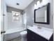 Bright bathroom with a tub and shower, modern vanity, and large mirror at 1235 Indiana Ave, Anderson, IN 46012
