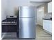 The kitchen features stainless steel appliances, gray walls, light wood flooring, and white cabinets at 1235 Indiana Ave, Anderson, IN 46012