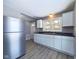 The kitchen features stainless steel appliances, gray walls, light wood flooring, and white cabinets at 1235 Indiana Ave, Anderson, IN 46012