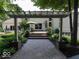 Landscaped backyard with pergola-covered walkway, creating a serene entrance to the outdoor space at 12484 E 156Th St, Noblesville, IN 46060