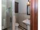 Tiled bathroom featuring a glass shower with a built-in niche, pedestal sink, and decorative mirror at 12484 E 156Th St, Noblesville, IN 46060