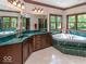 Bathroom with soaking tub, double vanity with green marble countertops, and ample natural light at 12484 E 156Th St, Noblesville, IN 46060