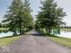 Long driveway through a tree lined landscape with a pond on either side provides a peaceful entrance at 12484 E 156Th St, Noblesville, IN 46060