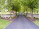Long driveway with American flag, leading to a stately home with a gated entrance and tree-lined landscape at 12484 E 156Th St, Noblesville, IN 46060