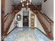 Grand foyer featuring a double staircase, marble floors, elegant chandelier, and a decorative rug at 12484 E 156Th St, Noblesville, IN 46060