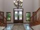 Elegant foyer with a split staircase, marble flooring, a chandelier, and views of the front yard through glass doors at 12484 E 156Th St, Noblesville, IN 46060