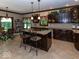 Spacious kitchen with a large island, dark wood cabinets, granite counters, and stainless steel appliances at 12484 E 156Th St, Noblesville, IN 46060