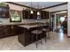 Kitchen island with seating, dark wood cabinets and stainless steel appliances at 12484 E 156Th St, Noblesville, IN 46060