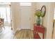 Bright foyer with decorative table, wood floors and a white door that leads to the front entrance at 1501 Willshire Dr, Greenwood, IN 46143