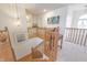 Bright landing with wood railing, view of stairs, desk, and decorative art pieces at 1501 Willshire Dr, Greenwood, IN 46143