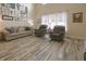 Comfortable living room featuring a plush sofa, reclining chairs, and natural light from the window at 1501 Willshire Dr, Greenwood, IN 46143