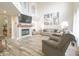 Open-concept living room with vaulted ceiling, fireplace, TV, and modern decor with hardwood floors at 1501 Willshire Dr, Greenwood, IN 46143