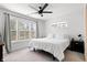 Bright bedroom with a ceiling fan, a large window with blinds, and neutral carpet at 1842 Milburn St, Indianapolis, IN 46202