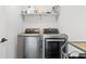 Laundry room equipped with modern washer and dryer units and overhead shelving at 1842 Milburn St, Indianapolis, IN 46202
