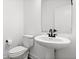 Elegant powder room featuring pedestal sink, black faucet and hardware, and a minimalist mirror at 1842 Milburn St, Indianapolis, IN 46202