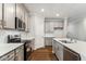 Modern kitchen featuring stainless steel appliances, white countertops, stylish cabinets, and wood flooring at 20238 Allegheny Ln, Westfield, IN 46074