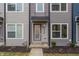 Attractive townhouse with a covered entry featuring muted siding, contemporary windows, and manicured landscaping at 2115 Coretta Way, Indianapolis, IN 46202
