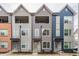 Modern townhome featuring varied neutral siding and individual entryways with small patios at 2115 Coretta Way, Indianapolis, IN 46202