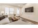Cozy living room features modern gray sofa, wood coffee table, and large-screen TV for relaxation at 2115 Coretta Way, Indianapolis, IN 46202