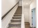 Carpeted staircase with a dark wood handrail and white walls leading to the upper level at 2115 Coretta Way, Indianapolis, IN 46202
