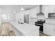 Modern kitchen boasts stainless steel appliances, a large island, and contemporary lighting at 2139 Coretta Way, Indianapolis, IN 46202
