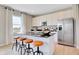 Bright kitchen boasts white cabinets, stainless appliances, a dark countertop island, and barstool seating at 4406 Mendocino Blvd, Indianapolis, IN 46075