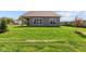 Rear exterior featuring a grassy yard, contemporary gray siding, and large windows at 5040 Carmine St, Brownsburg, IN 46112