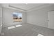 Well-lit bedroom showcasing neutral walls, carpet, and a window offering pleasant neighborhood views at 5040 Carmine St, Brownsburg, IN 46112