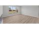 Light-filled bedroom featuring wood-look floors and a large window with a backyard view at 5040 Carmine St, Brownsburg, IN 46112