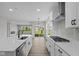 Open kitchen with white cabinets and countertops flowing to the living area at 5040 Carmine St, Brownsburg, IN 46112