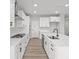 Modern kitchen features white cabinets, stainless appliances, island with a sink, and stylish lighting at 5040 Carmine St, Brownsburg, IN 46112