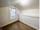 Finished attic with hardwood floors, neutral walls, and a view from the window at 5103 E St Clair St, Indianapolis, IN 46219